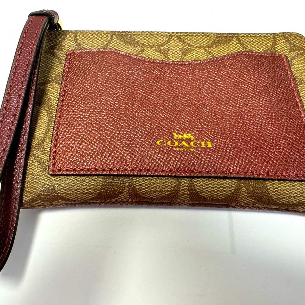 Coach leather wristlet with exterior pocket. Pre owned.